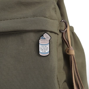 Detail of medical pill bottle enamel pin with IF YOU CAN'T MAKE YOUR OWN quote on canvas bag