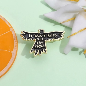 Broche corbeau noir créative avec citation It Can't Rain All The Time et bordure dorée