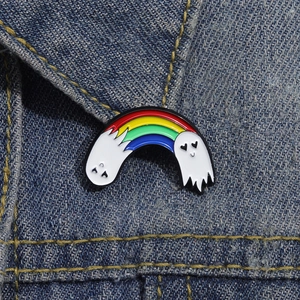 Detail of a rainbow ghost enamel pin on denim jacket showing vibrant colors and textures