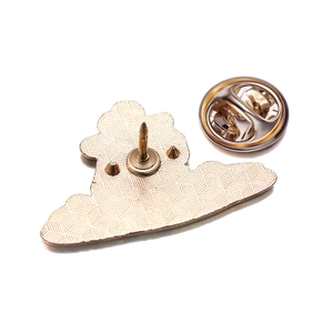 Macro detail of golden capybara enamel pin back showing the butterfly clutch and texture