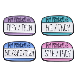 Set of four colorful enamel pronoun badges in speech bubble shapes for clothing lapels