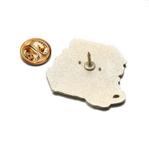 Detail view of the golden metal brooch back featuring sandblast finish and butterfly clutch