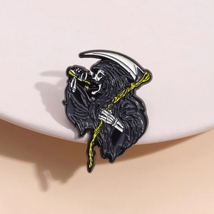 Vintage Grim Reaper enamel pin with black cloak and scythe on a white pedestal