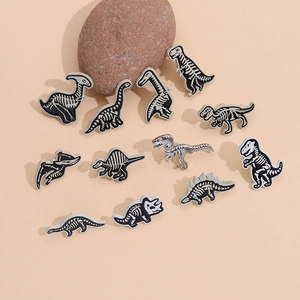 Punk style set of 11 assorted cartoon dinosaur skeleton enamel pins on beige stone surface