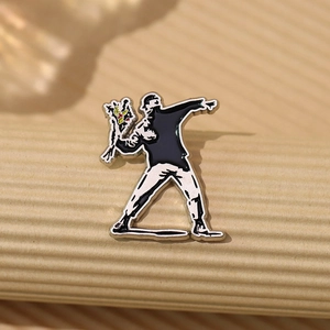 Detail of vintage enamel pin featuring Banksy flower thrower artwork on alloy badge
