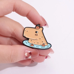 Cute Capybara enamel pin featuring a cartoon animal bathing in water with an orange on head
