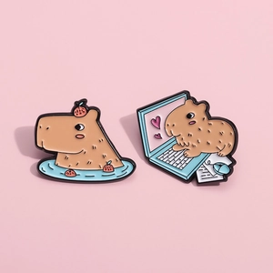 Detail of cute capybara enamel pins showing bathing design and computer work style