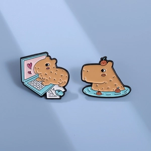 Cute cartoon capybara enamel pins featuring laptop and bath scenes on blue background