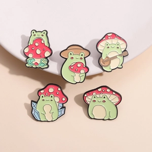 Set di cinque simpatiche spille smaltate con motivi di rane e funghi colorati