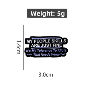 Close-up of black rectangular enamel pin with witty slogan and dimensional markings