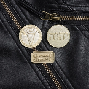 Detailed close-up of golden geometric badges pinned on a black leather jacket