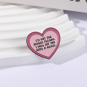 Pink heart enamel brooch with funny quote I'M NOT THE BIGGER PERSON displayed on white stand