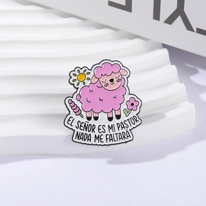 Broche en émail mouton rose avec citation espagnole sur un support de fond blanc
