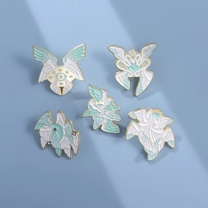 Five-piece Eye of Horus and Seraphim wing enamel pins set on a light blue background