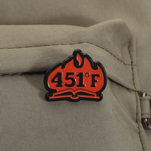 Gros plan du badge en émail 451°F avec motif de flammes sur un support en textile