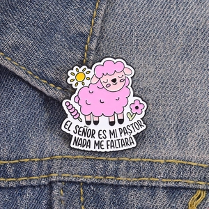 Gros plan sur l'épinglette de mouton rose avec texte espagnol sur veste denim