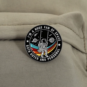 Detail einer runden Astronauten-Emaille-Anstecknadel mit Weltraum-Spruch auf Segeltuch
