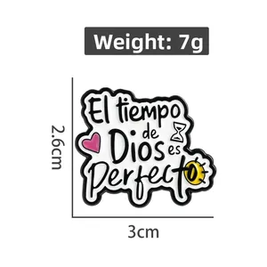Close-up of enamel pin with El tiempo de Dios es perfecto text and hourglass detail