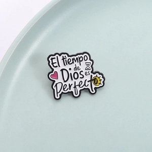 Enamel pin with Spanish text El tiempo de Dios es Perfecto, heart and hourglass icons