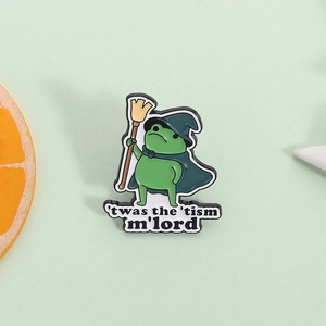 Cartoon frog wizard enamel pin with 'twas the 'tism m'lord text badge on green background