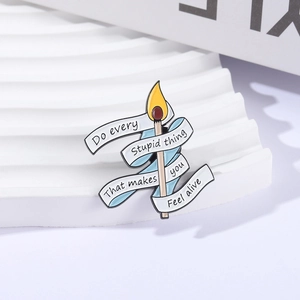 Spilla in smalto a forma di fiammifero con nastro blu e testo su supporto decorativo