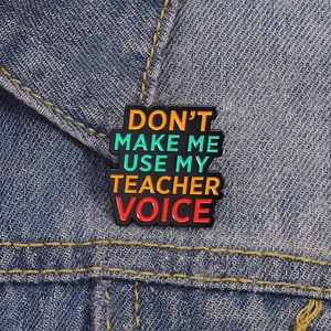 Funny enamel pin badge with 'Don't Make Me Use My Teacher Voice' on denim background