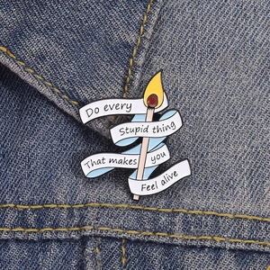 Cartoon matchstick enamel brooch pin with inspirational quote on denim background