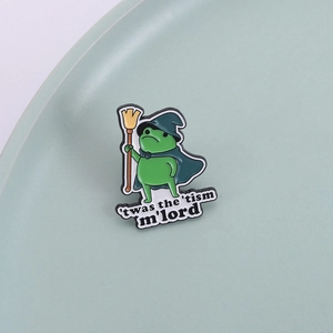 Cartoon frog wizard enamel pin with blue cape and broom on a light teal background