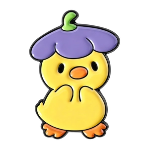 Macro detail of yellow duck enamel pin wearing a purple flower hat on white background