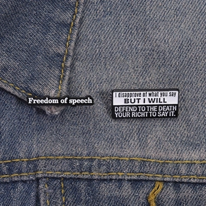 Καρφίτσες σμάλτου Freedom of Speech και Nope not today σε μπλε τζιν ύφασμα φόντου