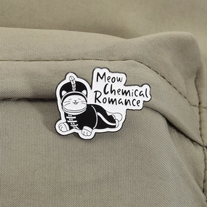 Macro detail of enamel cat brooch with Meow Chemical Romance text on canvas fabric