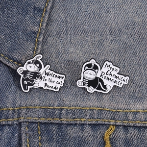 Cute cat parade enamel pins with black marching band uniforms on denim fabric background