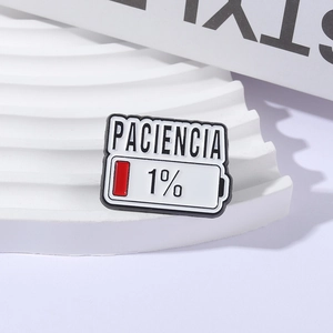 Kreative Patience 1% Emaille-Pin mit Batteriesymbol und spanischem Text auf Podest