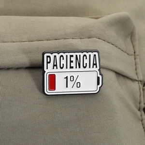 Detail der Paciencia 1% Emaille-Anstecknadel auf armeegrünem Canvas-Hintergrund