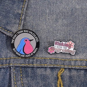 Funny enamel pin set featuring bird and floral designs on a blue denim background