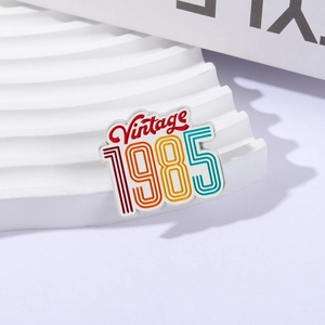 Vintage 1985 enamel brooch with colorful retro lettering on white wave display