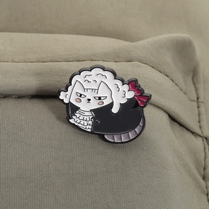 Detailed view of a quirky cat sheep enamel pin attached to a khaki canvas fabric texture