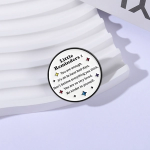 Inspirational circular enamel pin featuring 'Little Reminders' quotes and colorful stars