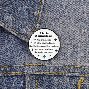 Round healing geometric badge pin with motivational quote on blue denim jacket