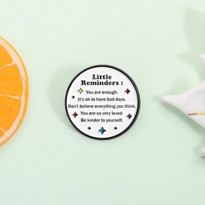 Inspirational Little Reminders enamel pin with stars and motivational quotes on white round badge