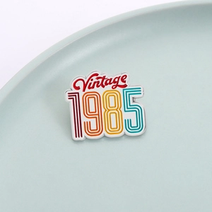 Retro 1985 neon style enamel brooch badge in vintage metal finish on ceramic dish