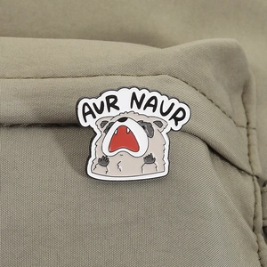 Detailed enamel pin showing a screaming raccoon with AUR NAUR text on olive green fabric