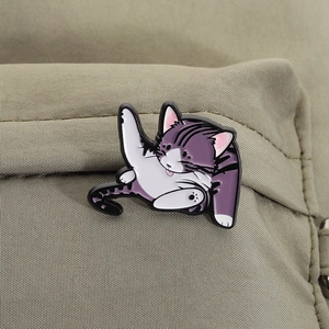 Detail of purple striped cat enamel pin attached to a khaki canvas backpack strap