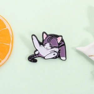 Cute purple and white enamel cat brooch pin in a playful pose on a pastel background