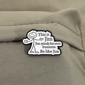 Macro shot of This is Jim funny stickman enamel pin on khaki canvas fabric texture
