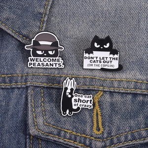 Funny black cat enamel pin set with humorous English quotes on blue denim jacket