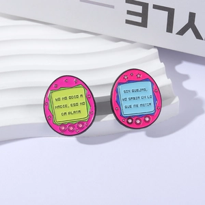 Colorful Tamagotchi style enamel pins with Spanish quotes for clothes and bags