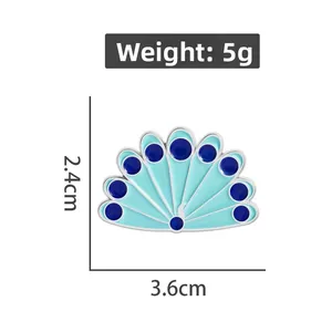Broche en émail paon montrant des dimensions de 2,4 cm x 3,6 cm sur fond blanc