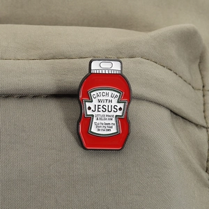 Detail der roten Ketchup-Emaille-Brosche mit Spruch auf braunem Segeltuch
