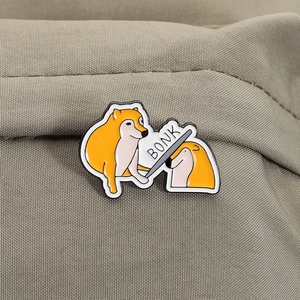 Macro detail of Shiba Inu Bonk meme enamel pin attached to khaki canvas fabric